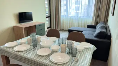 a living room with a table with plates and dishes on it at Evi Apartments 2 in Pomorie