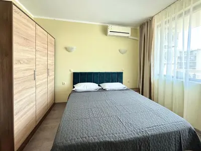 a bedroom with a bed and a large window at Evi Apartments 2 in Pomorie