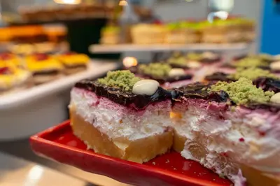 a red plate with a piece of cake on a table at MPM Hotel Orel - Ultra All Inclusive in Sunny Beach
