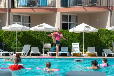 a woman playing with a frisbee in a swimming pool at MPM Hotel Orel - Ultra All Inclusive in Sunny Beach