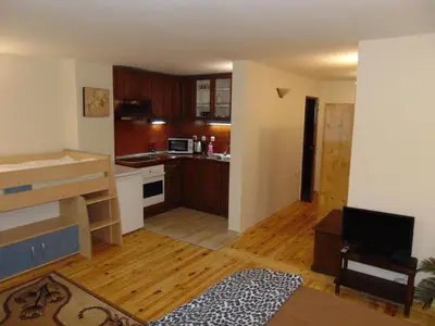 a living room with a kitchen with wooden floors at Burgas Central Aleksandrovska in Burgas City