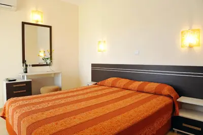a hotel room with a bed and a mirror at Hotel Iris in Nesebar