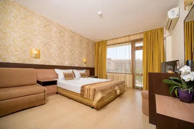 a hotel room with a bed and a couch at Hotel Iris in Nesebar