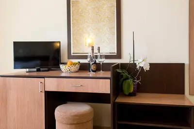 a room with a desk with a television and a stool at Hotel Iris in Nesebar