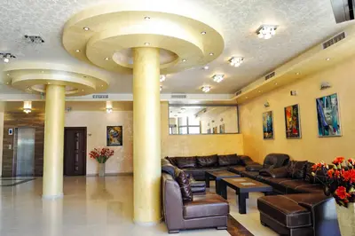 a lobby with couches and tables and a large ceiling at Hotel Iris in Nesebar