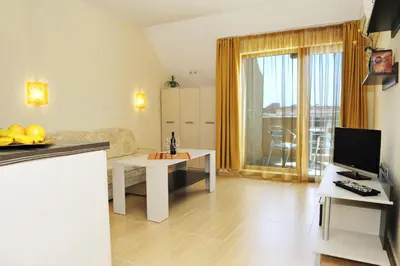 a living room with a kitchen and a room with a table at Hotel Iris in Nesebar