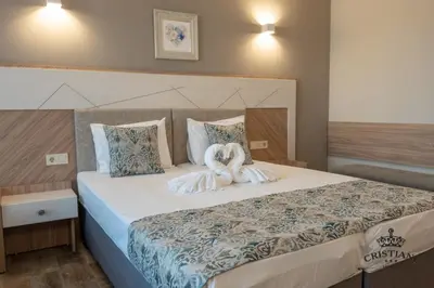 a bedroom with a bed with two towels on it at Cristiani Hotel Sozopol in Sozopol
