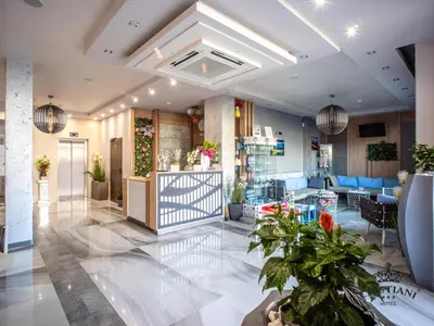 a lobby with potted plants in a building at Cristiani Hotel Sozopol in Sozopol