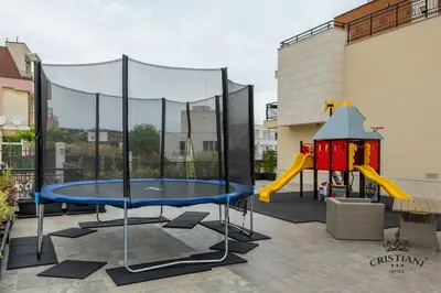 a play area with a table and a playground at Cristiani Hotel Sozopol in Sozopol