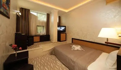 a bedroom with a bed and a window and a television at Efbet Hotel in Varna City