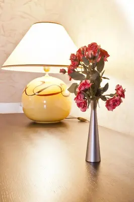 a lamp and a vase with flowers on a table at Efbet Hotel in Varna City