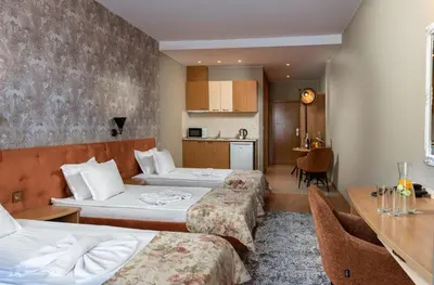 a hotel room with two beds and a table at Hotel Avenue in Sunny Beach