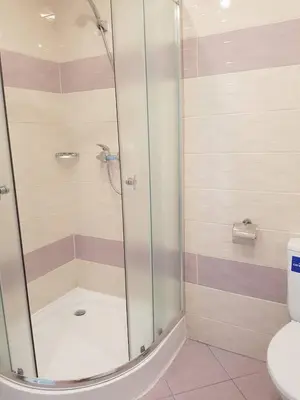 a shower with a glass door in a bathroom at Guest House Evtimov in Primorsko
