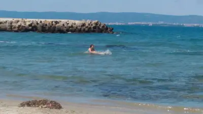 a person swimming in the ocean near a beach at Studio Eva 31 in Pomorie
