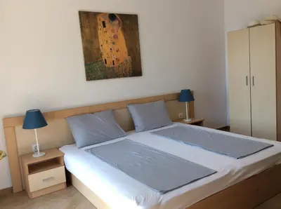 a bedroom with a bed with a painting on the wall at Seaside Apartment in Sozopol
