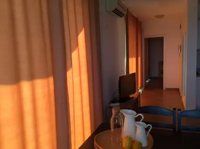 a living room with a table and a room with a television at Seaside Apartment in Sozopol