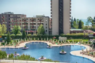 a large swimming pool with chairs and tables in a city at Royal Beach Apartments in Sunny Beach