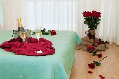a table with two glasses of wine and roses on it at Sea Dream Rental Apartments in Varna City