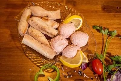 a plate of food with meat and bread on a table at Rodos House in Pomorie