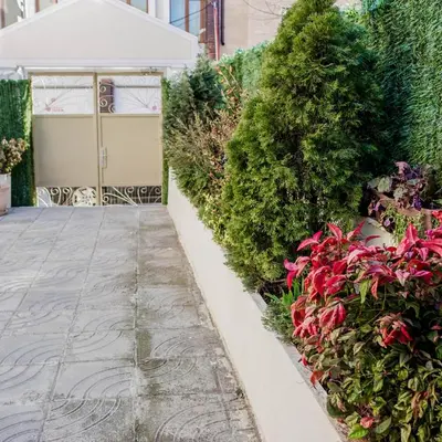 a driveway with flowers in front of a garage at Hotel Acropolis in Varna City