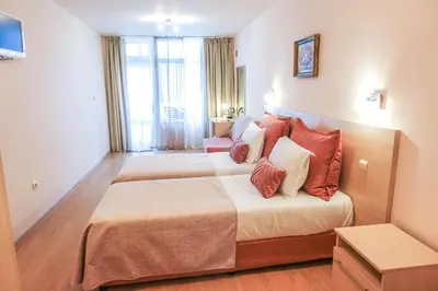 a hotel room with two beds with red pillows at Hotel Acropolis in Varna City