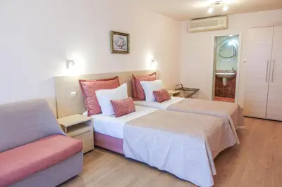 a hotel room with two beds and a couch at Hotel Acropolis in Varna City