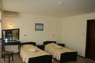 a hotel room with two beds and a desk at Hotel Klisura in Sunny Beach