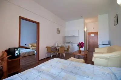 a bedroom with a large bed and a living room at Regina Hotel in Sunny Beach