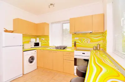a kitchen with yellow and white stripes on the wall at BulgariaVilla - Villa Knox in Bryastovets