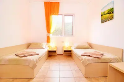 two beds in a room with a window and two lamps at BulgariaVilla - Villa Knox in Bryastovets