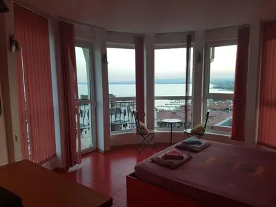 a room with large windows with a bed and a view of the ocean at Hotel Saint Tatyana in Sveti Vlas