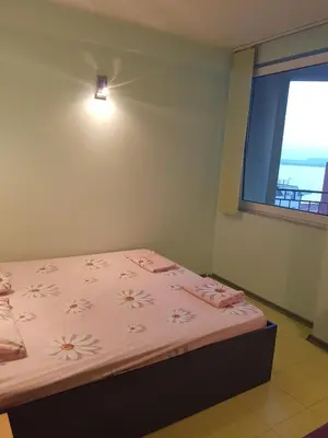 a bedroom with a bed with pink sheets and a window at Hotel Saint Tatyana in Sveti Vlas