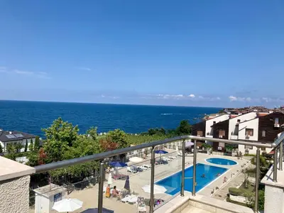 a view of a swimming pool and the ocean at Apolon Complex in Sozopol