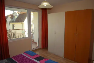 a bedroom with a bed and a window with a balcony at CITY STAY in Varna in Varna City