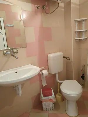 a pink and white bathroom with a toilet and sink at CITY STAY in Varna in Varna City