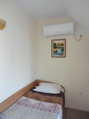a bedroom with a bed and a air conditioner on the wall at Barex Family Hotel in Sozopol