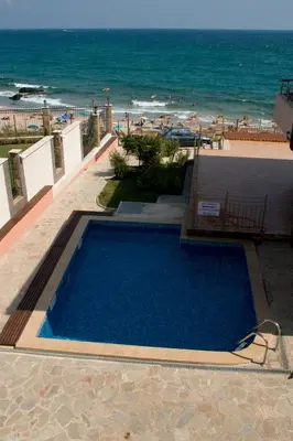 a swimming pool with the beach in the background at Barex Family Hotel in Sozopol