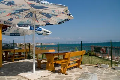 a picnic table with an umbrella on the beach at Barex Family Hotel in Sozopol