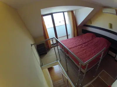 a small room with a bunk bed and a staircase at Hotel Apolis in Sozopol
