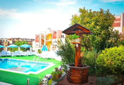 a swimming pool with a bird house next to a building at Hotel Apolis in Sozopol