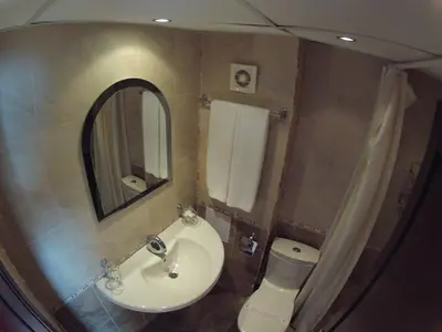 a bathroom with a sink and a toilet and a mirror at Hotel Apolis in Sozopol