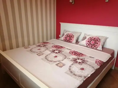 a bed with pink and white blankets and pillows on it at Apartments Del Sol - Sunny Island Complex in Chernomorets