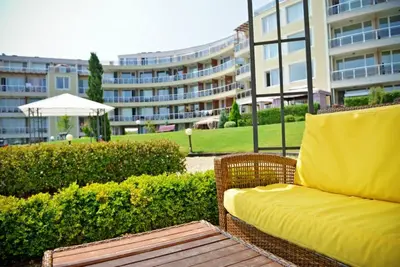 a yellow couch sitting in front of a building at Apartments Del Sol - Sunny Island Complex in Chernomorets
