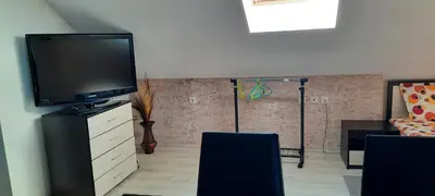 a living room with a flat screen tv on a dresser at Студио Изгрев in Burgas City