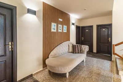 a room with a white chair in a hallway at Kalithea Family Hotel in Sozopol