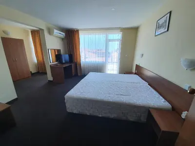 a hotel room with a bed and a television at Sandor Hotel in Nesebar