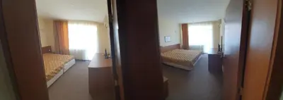 a room with two beds and a door to a bedroom at Sandor Hotel in Nesebar