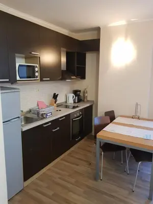 a kitchen with a table and a white refrigerator at Apartment with Sea View in Obzor Beach in Obzor
