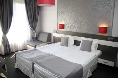 a bedroom with a large white bed and a chair at Gran Via in Burgas City