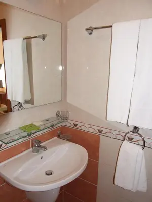 a bathroom with a white sink and a mirror at Family hotel Tropicana in Ravda